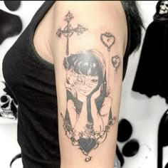 a woman with a black and white tattoo on her arm is holding a cross in the shape of a heart