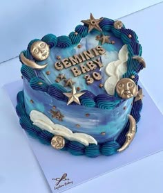 a blue cake with gold stars and moon decorations