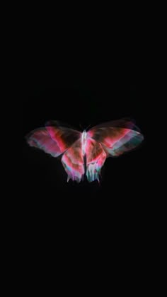 a butterfly flying in the dark with its wings spread