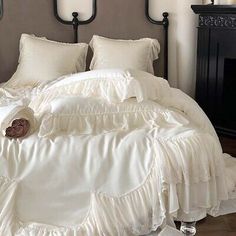 a bed with white ruffled bedspread and pillows