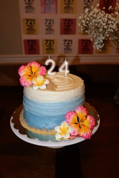 a blue and white cake with flowers on it