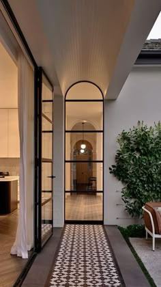 an outdoor living area with tiled flooring and glass doors