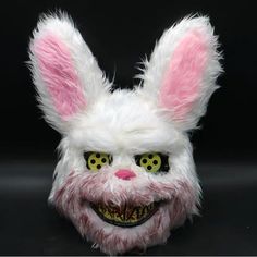 a white bunny mask with green eyes and pink hair on a black background, the head is slightly to the side