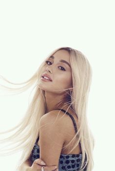 a woman with long blonde hair standing in front of a white background