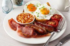 a plate with eggs, beans and sausage on it