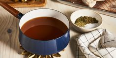 a cup of tea sitting on top of a wooden table next to other food items