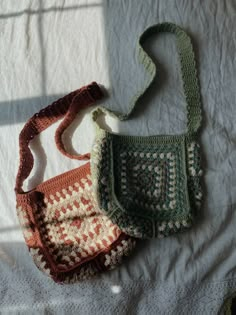 three crocheted purses sitting on top of a white bed next to each other