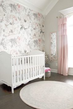 a baby's room with floral wallpaper and white crib in the corner