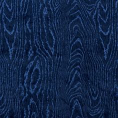 a dark blue background that looks like wood grains on a piece of furniture or carpet