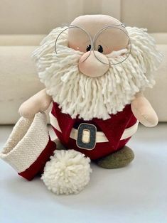 a stuffed santa claus with glasses and a red sweater