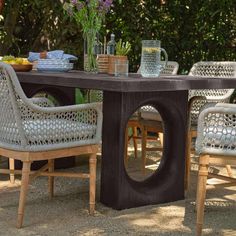 an outdoor table with chairs around it