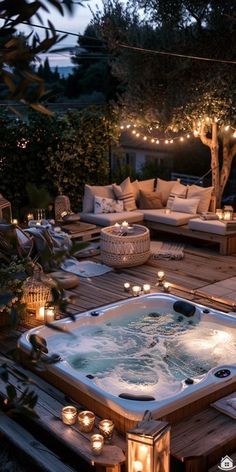 an outdoor hot tub surrounded by candles and lights in the middle of a wooden deck