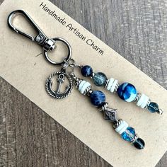 a pair of blue and white glass beaded earrings on a card with the name handmade artisan charm