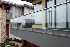 an outside view of a house with glass balconies on the balcony and side walk