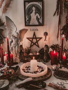 a table topped with candles and angels surrounded by other items