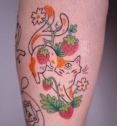 a woman's leg with tattoos on it and an image of a cat eating strawberries