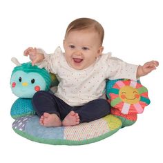 a baby sitting on top of a stuffed animal with his arms out and hands in the air