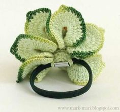 a crocheted flower on a black rubber band