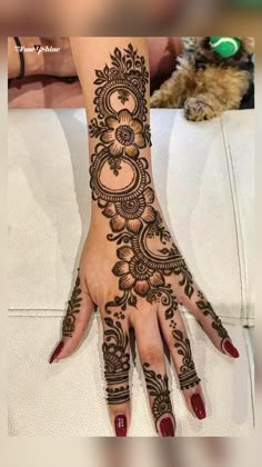 a woman's hand with henna tattoos on it