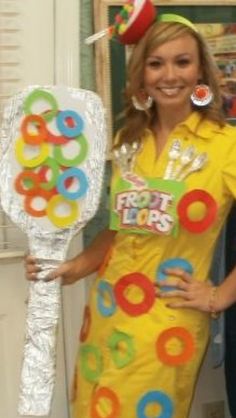 a woman in a yellow dress holding a bunch of doughnuts