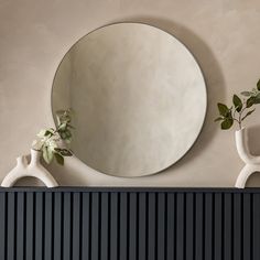 two vases and a mirror on top of a radiator