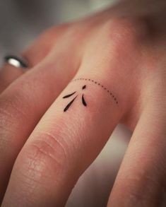 a person's hand with a small tattoo on it