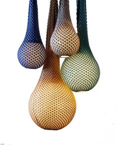 three different colored vases hanging from the ceiling in front of a white background,