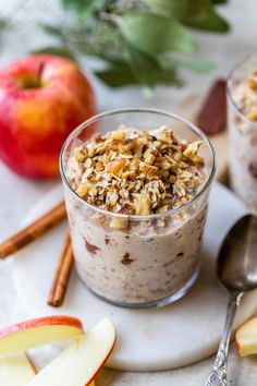 two small bowls filled with oatmeal next to an apple and cinnamon stick