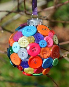 a colorful ornament hanging from a tree filled with buttons