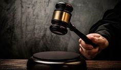 a person holding a wooden gavel in front of a table with a quote on it