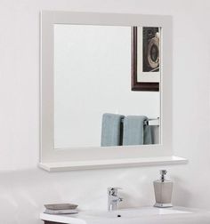 a bathroom sink with a mirror above it and towels hanging on the wall next to it