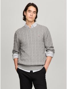 Tommy Hilfiger men's sweater. Made from soft cotton in a textured cable knit weave, this crewneck sweater is the perfect layer, complete with rib-knit cuffs, collar and hem with touches of subtle branding throughout.  Material: 100% Cotton. Tommy Hilfiger Sweater With Ribbed Cuffs For Fall, Tommy Hilfiger Fall Sweater With Ribbed Cuffs, Classic Cable Knit Crew Neck Sweater, Tommy Hilfiger Classic Crew Neck Sweater, Classic Textured Knit Sweater, Classic Cotton Cable Knit Sweater, Tommy Hilfiger Classic Winter Sweater, Tommy Hilfiger Classic Fall Sweater, Classic Tommy Hilfiger Sweater For Fall