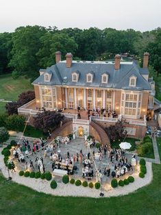 an aerial view of a large house with many people around it