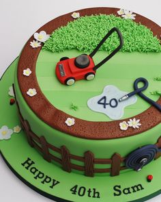 a birthday cake with a lawnmower and flowers on it