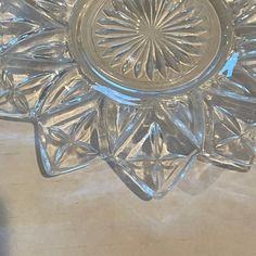 a clear glass dish with an intricate design on the bottom and center piece in the middle