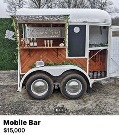 an old mobile bar is parked in the dirt