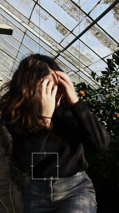 a woman talking on a cell phone in a greenhouse