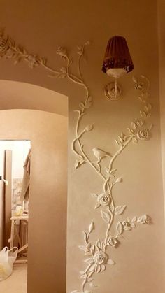 a lamp is hanging on the wall next to a flowered design in a bathroom