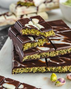 there are chocolate bars stacked on top of each other with white and green toppings