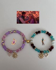 two bracelets with charms on them sitting next to an image of a man and woman