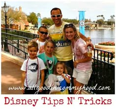 a family posing for a photo in front of the disney tips n tricks sign