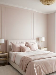 a bed with pink sheets and pillows in a bedroom next to a lamp on a nightstand