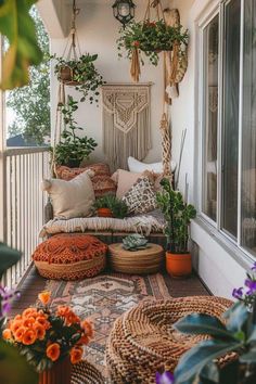 an outdoor porch with plants and pillows on the floor, potted plants hanging from the ceiling