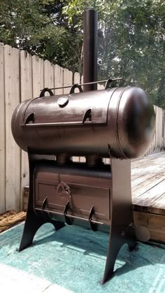 an outdoor wood burning stove on top of a blue rug in front of a wooden deck