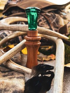 a green glass on top of a wooden post next to antlers and other items