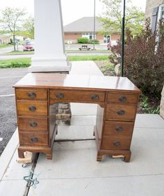 a wooden desk sitting on top of a sidewalk next to a white obelisk