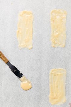 four pieces of cake sitting on top of a pan with icing and a spatula