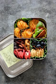 a bento box filled with different types of food on top of a cement floor