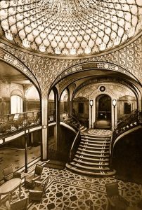 the inside of a train station with stairs and chandelier in sepia tone