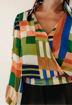 Update your wardrobe with the Fantasia Tie Waist Blouse. This vibrant top features a stunning green, orange, and navy print, while the shirt collar and surplice neckline add a touch of sophistication. The side waist tie creates a flattering fit, while the 100% polyester fabric makes it comfortable and easy to care for. With blouson long sleeves and a smocked back waistband, this blouse is the perfect blend of style and comfort. Elevate any outfit with this must-have addition to your wardrobe. Chic Multicolor Print V-neck Blouse, Chic V-neck Top With Bold Print, Green V-neck Top With Vibrant Print, Chic Green Tops With Abstract Print, Green Abstract Print Tops For Spring, Spring Green Tops With Abstract Print, Green Abstract Print Top For Spring, Chic Green Blouse With Abstract Print, Spring Green Top With Abstract Print